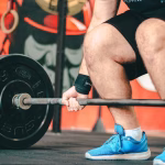Man performing strength training workout in gym, focusing on muscle building and proper form