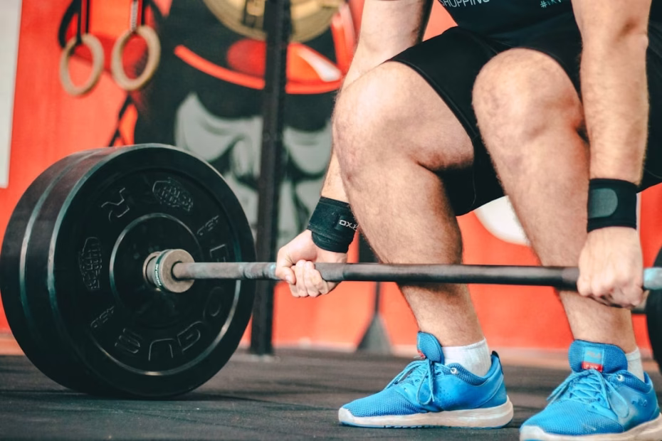 Man performing strength training workout in gym, focusing on muscle building and proper form