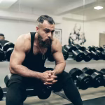 Fatigued man resting after intense gym session showing signs of overtraining and burnout