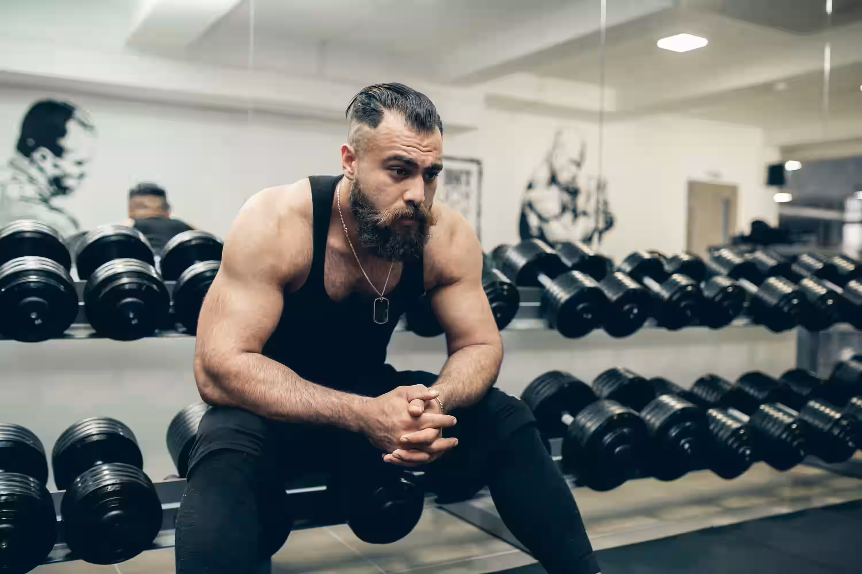 Fatigued man resting after intense gym session showing signs of overtraining and burnout