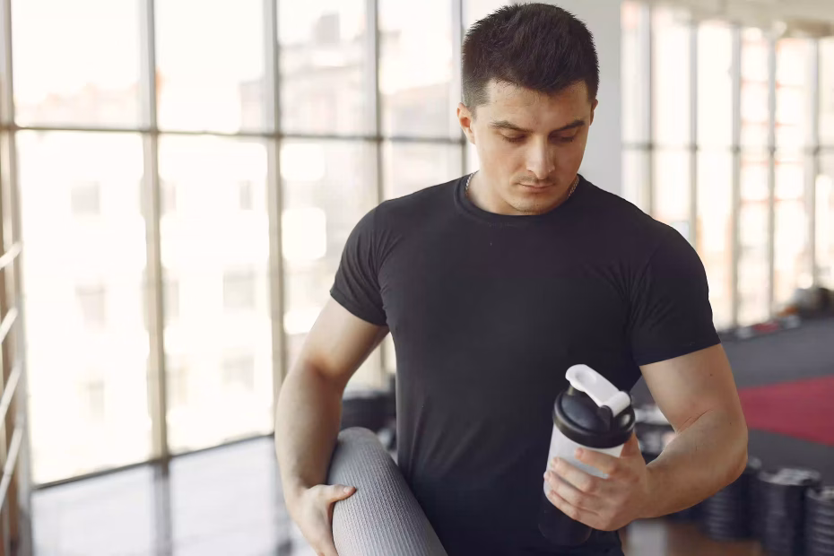 Man shaking a bottle containing protein powder, illustrating the use of protein supplements and potential side effects of protein supplements